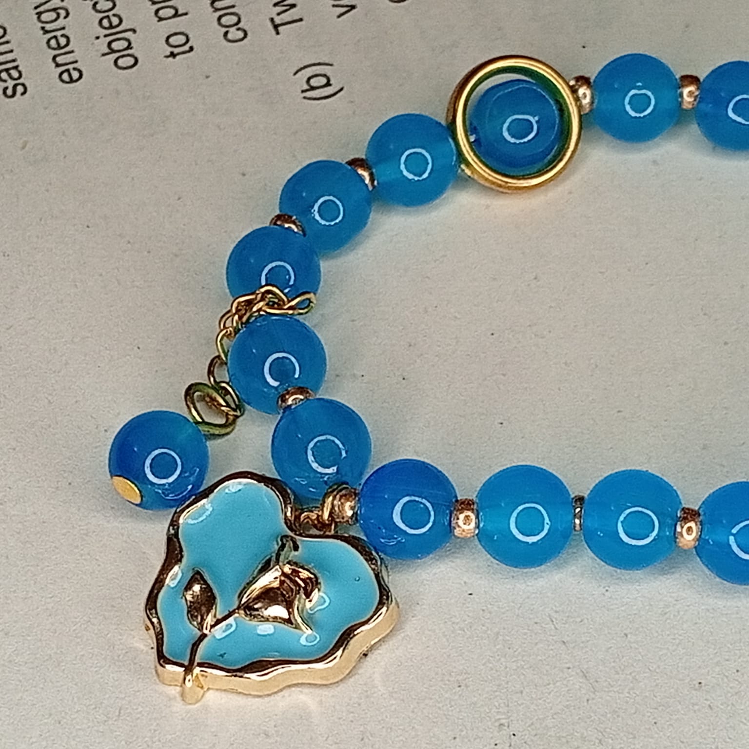 Vibrant Teal Blue Smooth Bead Bracelet with Gold-Trimmed Flower Charm
